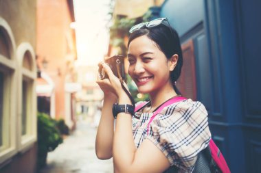 Genç hippi kadın sırt çantasıyla şehir merkezinde fotoğraf çektirirken..