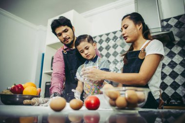 Mutlu aile, evdeki mutfakta birlikte yemek yaparken iyi vakit geçiriyor. Aile kavramı.