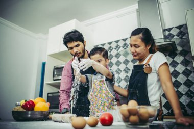 Mutlu aile, evdeki mutfakta birlikte yemek yaparken iyi vakit geçiriyor. Aile kavramı.