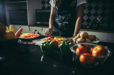 Kadın eli yakın. Ev yapımı pizzanın üstüne konur..
