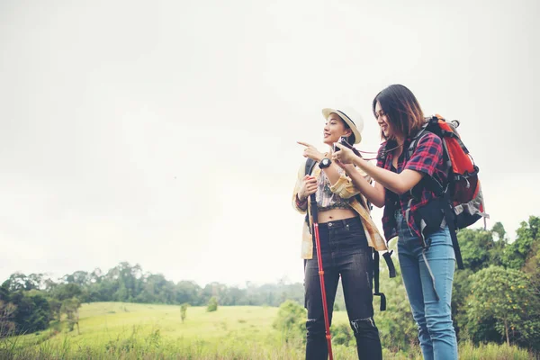 Two of hiking woman standing taking photo have resting after hike to the mountain.