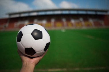 Stadyum arka planında çimlerin üzerinde futbol topu
