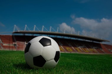 Stadyum arka planında çimlerin üzerinde futbol topu