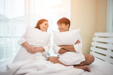 Mutlu genç çift yatakta eğleniyor.