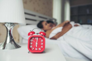 Evde rahat uyuyan bir çiftin olduğu kırmızı alarm saati.
