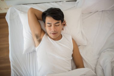 Adam sabahları yatakta uyuyor.