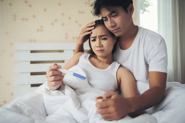 Λυπημένος Γονέας Διαμαρτύρονται Κρατώντας Ένα Τεστ Εγκυμοσύνης Κάθεται Στο Κρεβάτι — Φωτογραφία Αρχείου