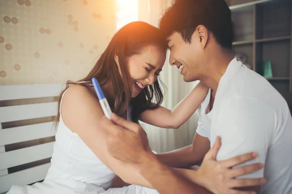 幸せなカップル笑顔後に見つける正妊娠テストでベッドルーム — ストック写真