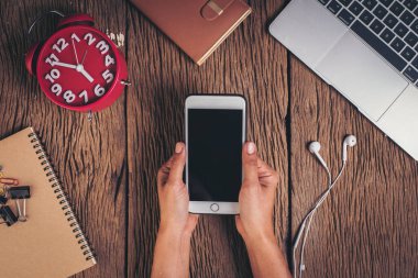 Ahşap arka planda üst görünüm telefon ve çalışma alanı