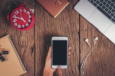 Ahşap arka planda üst görünüm telefon ve çalışma alanı