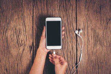 Üst görünüm ahşap zemin üzerinde telefon şarj