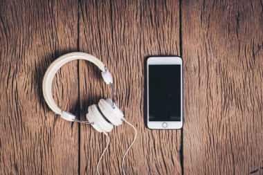 Üst görünüm telefon ve kulaklık ahşap arka plan