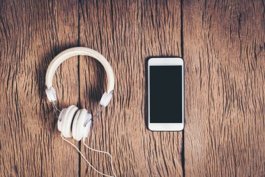 Üst görünüm telefon ve kulaklık ahşap arka plan