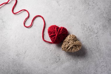 Duvarın arka planında kırmızı iplik kalbi var.