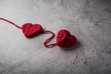 Duvarın arka planında kırmızı iplik kalbi var.