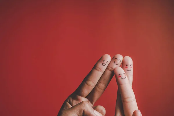 Finger with emotion on red background