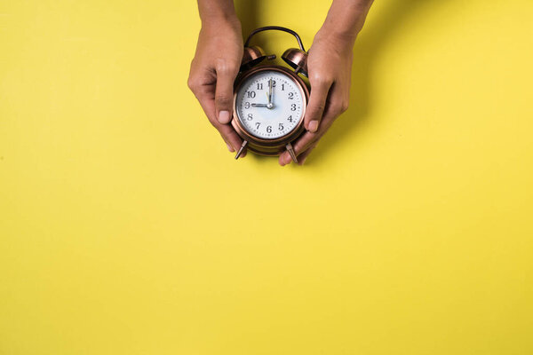 Top view hand and alarm clock