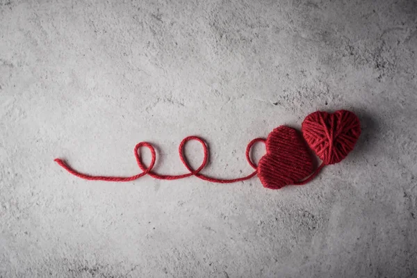 Duvarın arka planında kırmızı iplik kalbi var.