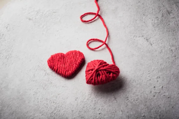 Red yarn heart shaped on the wall background