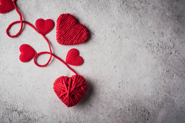 Red yarn heart shaped on the wall background