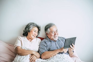 Tablet bilgisayar kullanan yaşlı çift