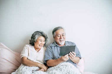 Tablet bilgisayar kullanan yaşlı çift