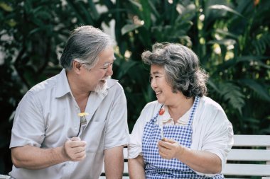 Yaşlı çiftler birlikte sağlıklı yemekler pişiriyor.