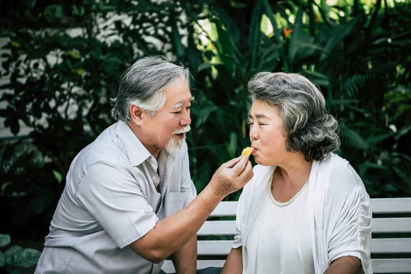 高齢者のカップル遊びやいくつかの果物を食べる — ストック写真
