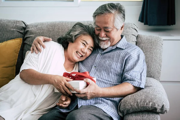 Elderly Couples Surprise and gift box at living room