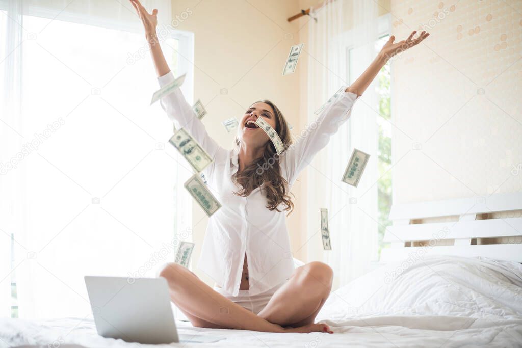 Woman with dollar bank note on the bed