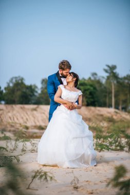 Asyalı gelin ve beyaz damat romantik zaman geçirir ve birlikte mutlu olurlar. 