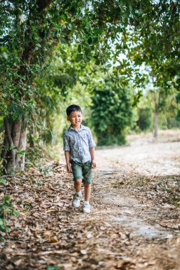 Mutlu çocuk parkta tek başına oynuyor.