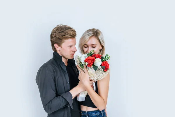 幸福的年轻夫妇在演播室里的爱情与花朵的画像 — 图库照片