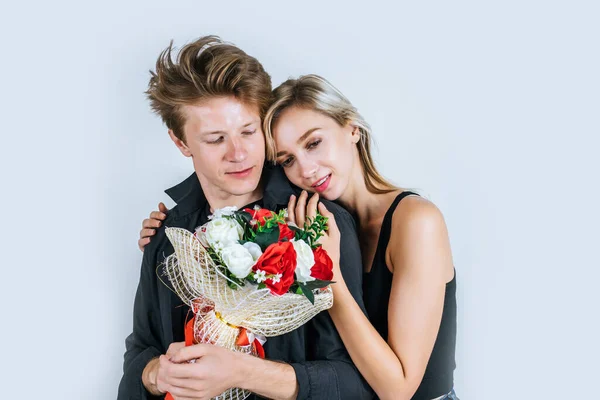 幸福的年轻夫妇在演播室里的爱情与花朵的画像 — 图库照片