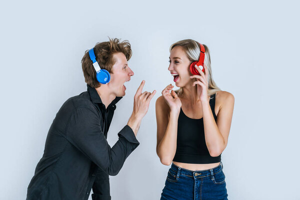 happy young couple in headphones listening music in studio