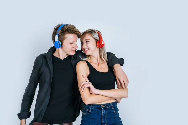 快乐的年轻夫妇戴着耳机在录音室里听音乐 — 图库照片