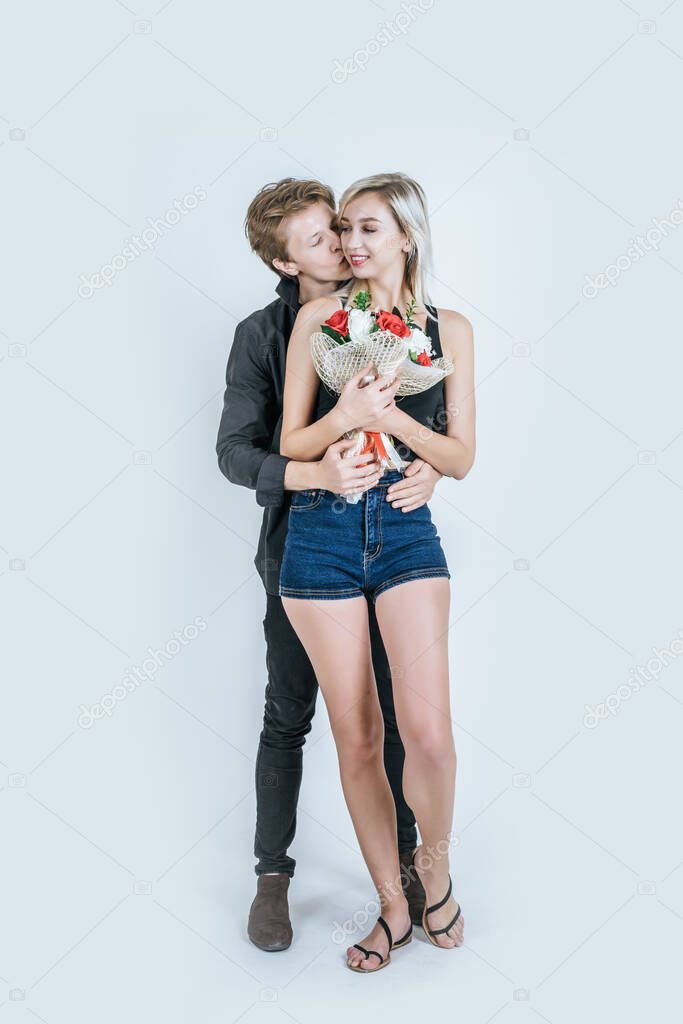 Portrait of happy young couple love together with flower in studio