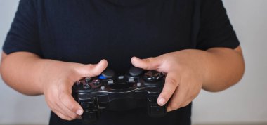 Mutlu çocuk stüdyo fotoğrafında bir kontrolörle oyun oynuyor.