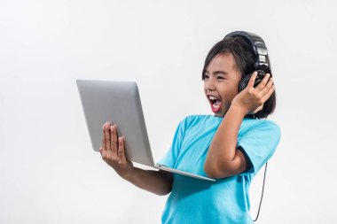 Dizüstü bilgisayar ve dinleme dersleri kullanan küçük bir kız. 