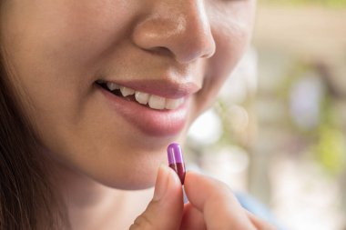 Doktor siparişinden sonra ilaç alan genç bir kadın.