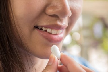 Doktor siparişinden sonra ilaç alan genç bir kadın.