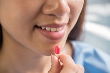 Doktor siparişinden sonra ilaç alan genç bir kadın.