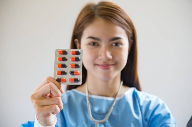 Kadın eczacı elinde doktor siparişinden reçeteli ilaç tutuyor.