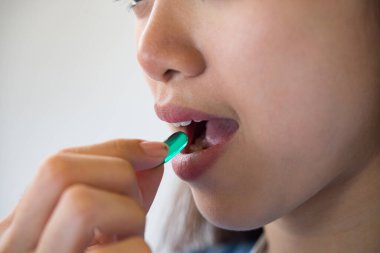 Doktor siparişinden sonra ilaç alan genç bir kadın.