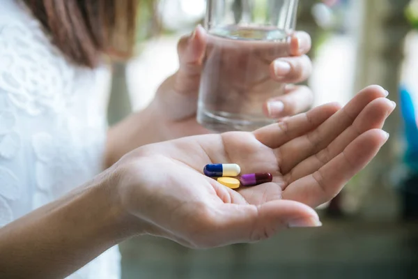 Woman\'s hand pours the medicine pills out of the bottle