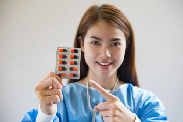 Woman pharmacist holding prescription medicine from doctor order