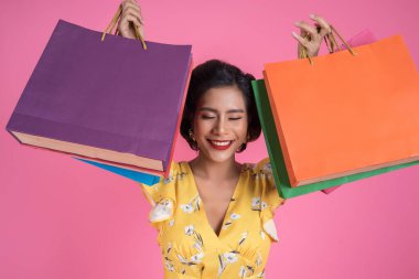 Güzel Asyalı kadın renkli alışveriş torbaları tutuyor.