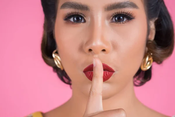 Beauty asian woman red lips and finger showing hush silence sign