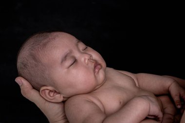 Bebek güçlü bir babanın ellerinde uyuyor..