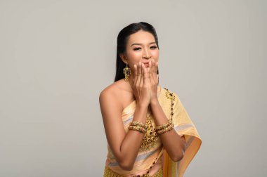 Taylandlı güzel bir kadın Tayland elbisesi ve mutlu bir gülümseme giyiyor..